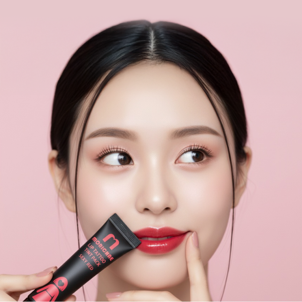 A model touching the Morichae Lip Tattoo Tint Pack to her lips, highlighting smooth texture and natural color glow after tinting.
